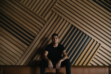 sculptural wooden wall with person sitting in the middle