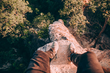 shoed feet overlooking cliff edge