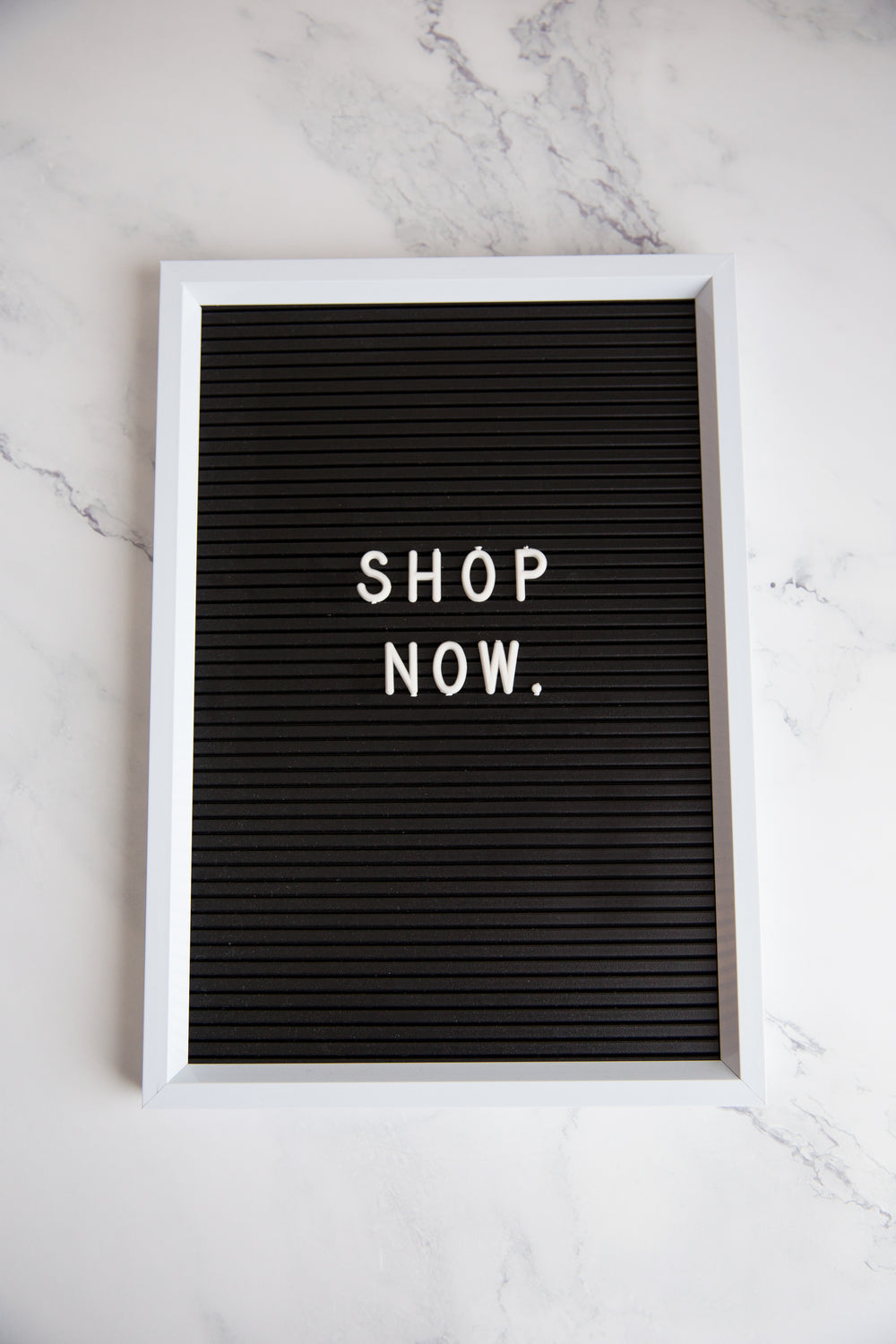 shop now sign on marble