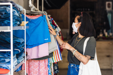 shopper browses clothes store in face mask