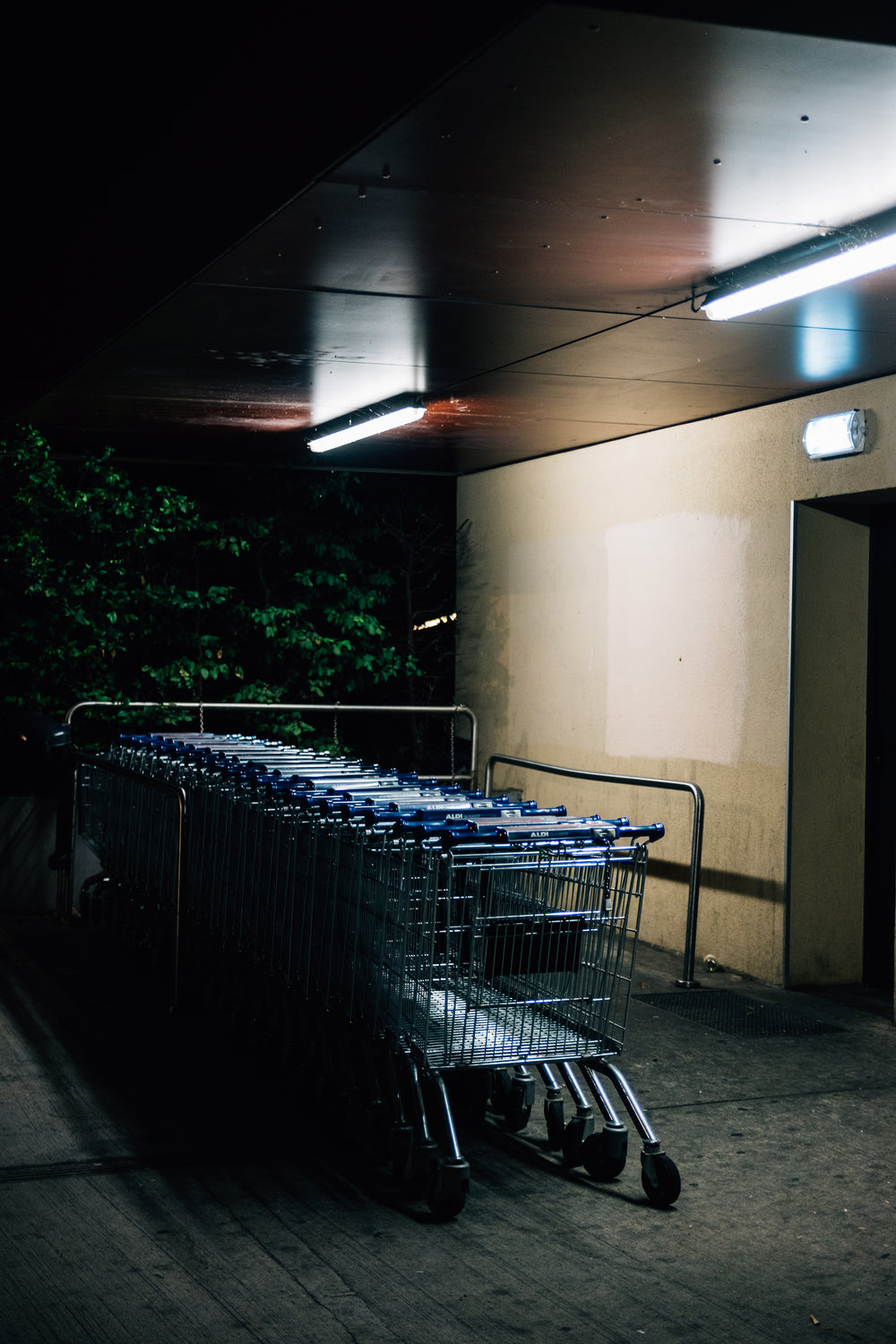 shopping carts parked outdoors beside a cement wall