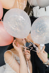 shy couple kisses behind balloons