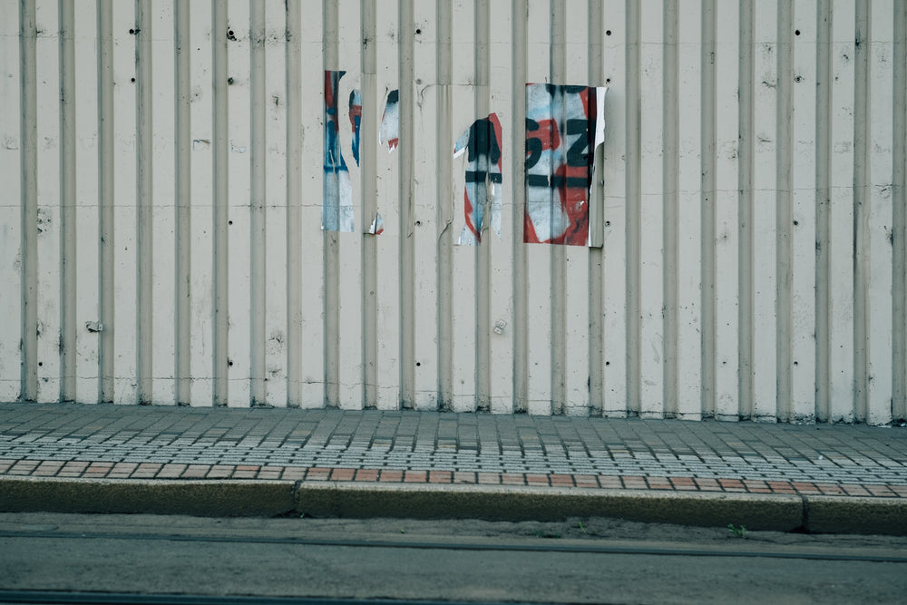 side of a building with remains of an old poster