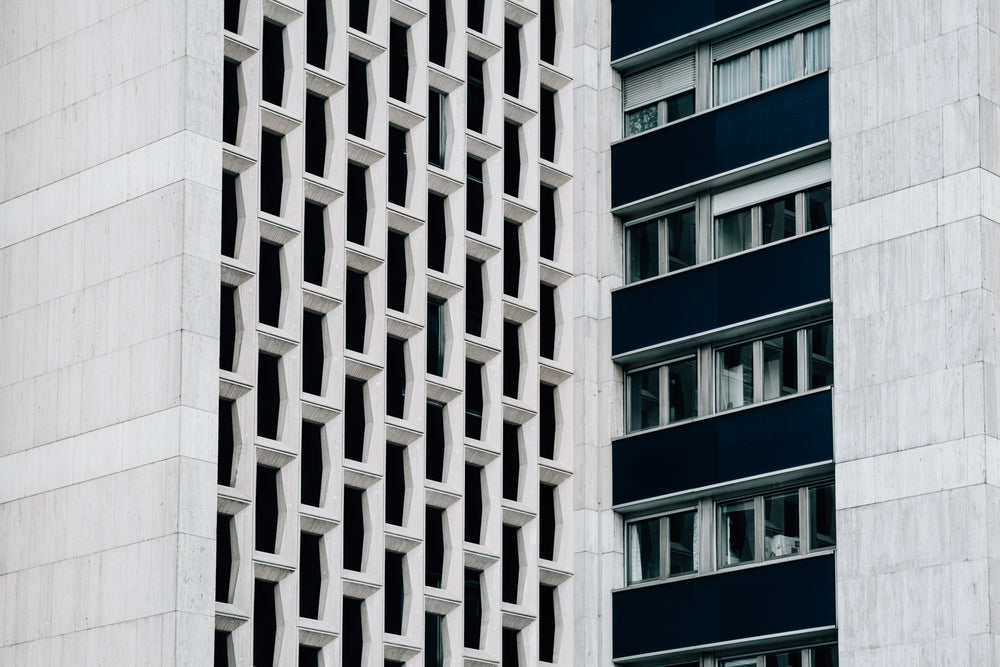 side of white building with windows and black balconies