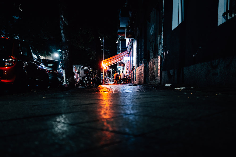 sidewalk brightened by city lights