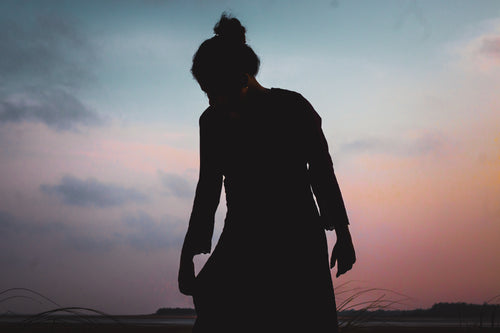 silhouette of a person against a pink and blue sky