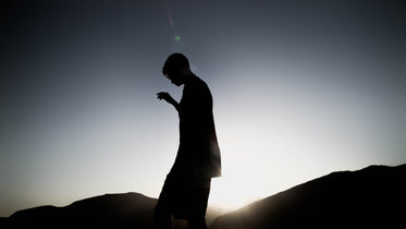 silhouette of a person standing hilly landscape