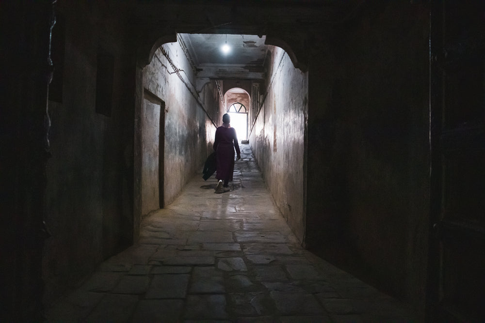 silhouetted person walks down a tunnel