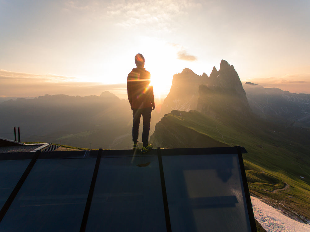 silhoutted hiker at mountain peak