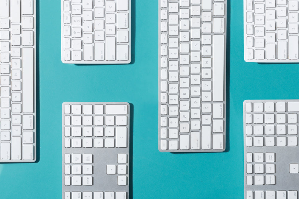 silver and white keyboards flat lay