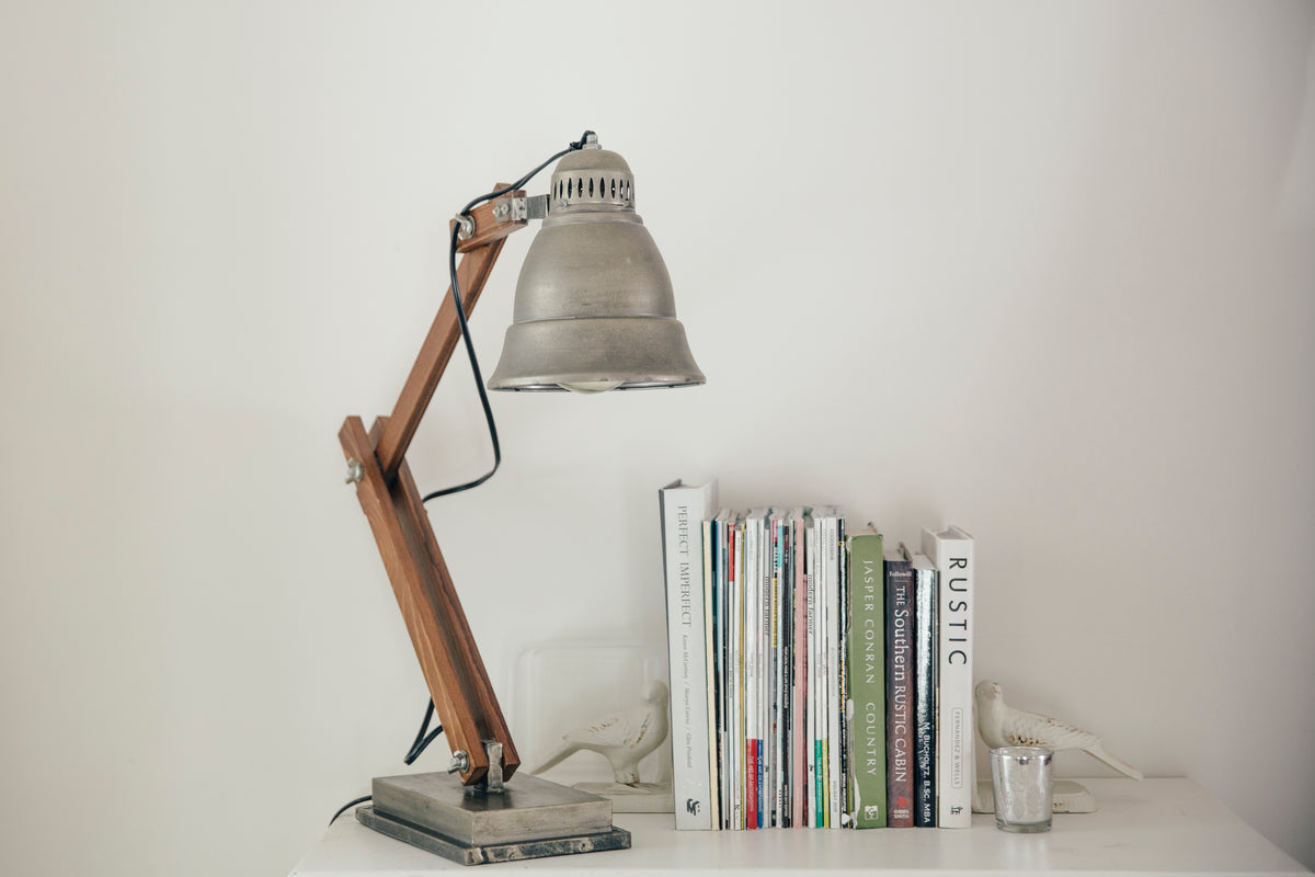 silver lamp on a white table next to books