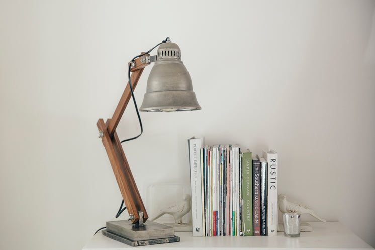 Silver Lamp On A White Table Next To Books