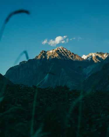 single cloud hovers over mountain peak