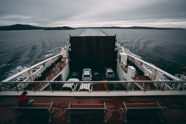 sitting atop a ferry travelling across water