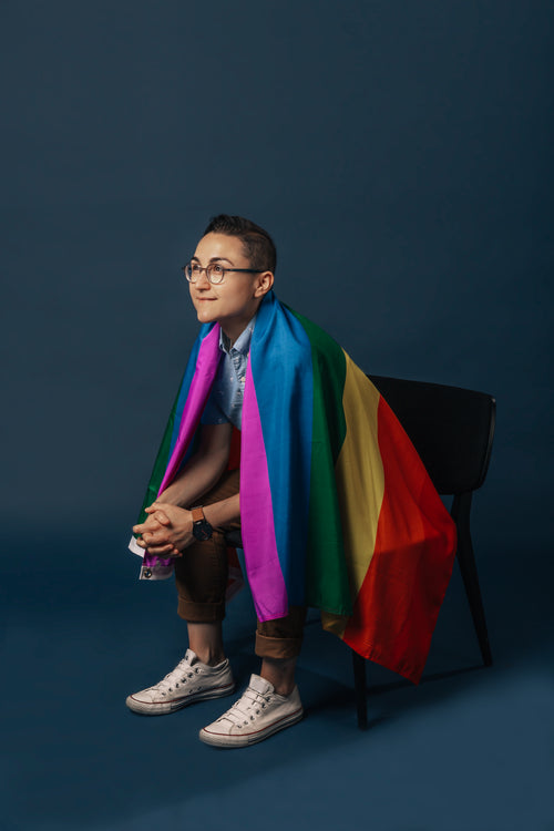 sitting in chair wrapped in pride flag