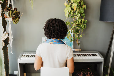 sitting in front of a piano keyboard