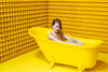 sitting in the bath in a yellow room