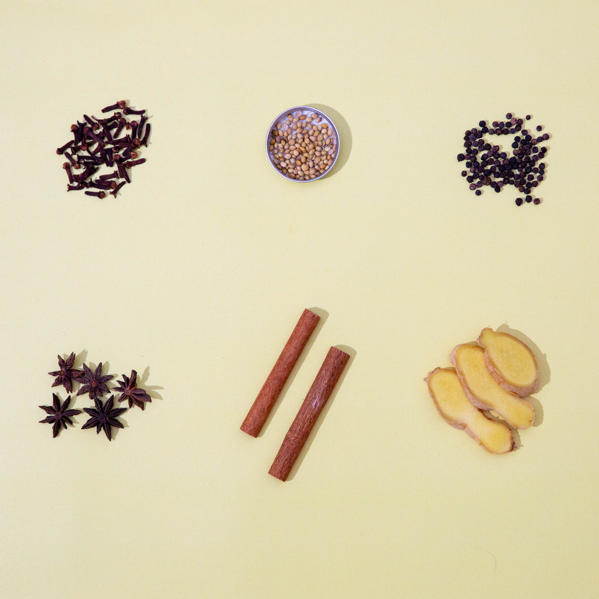 six different spices against a yellow background