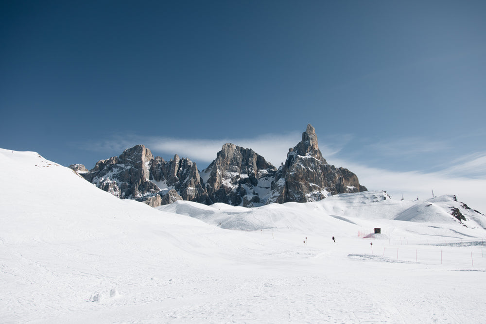 ski tracks at the foot of a rocky mountain range