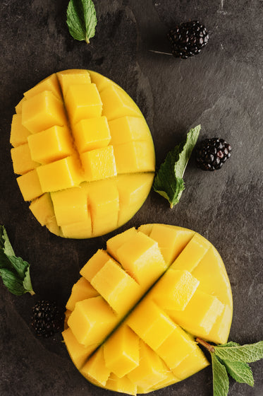 sliced mango accompanied by mint leaves