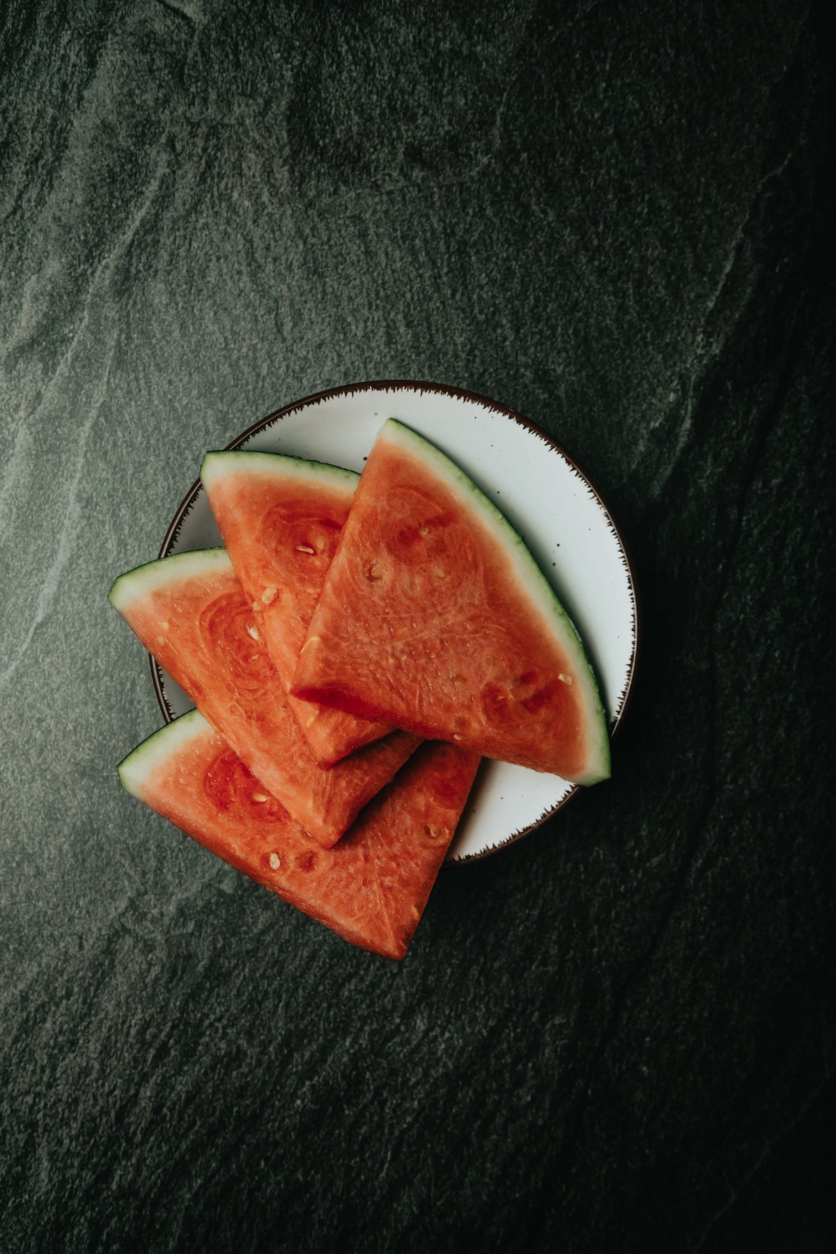 sliced watermelon fanned out on a white plate