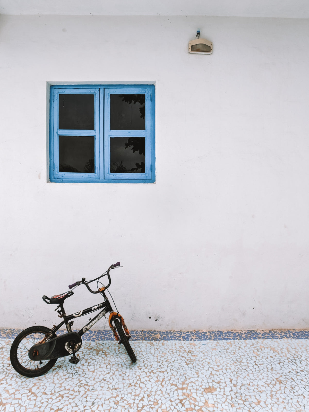 small bike under blue window frame