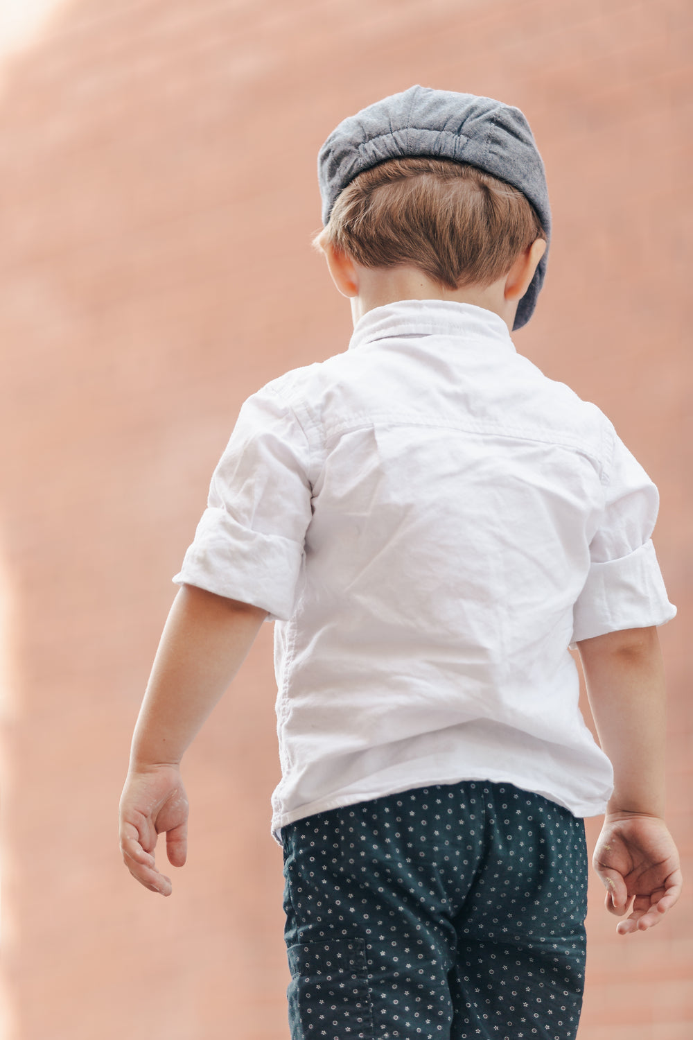 small boy in white shirt and grey hat