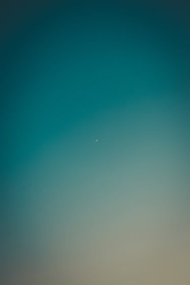 small crescent moon in blue sky