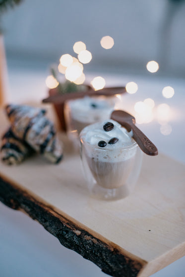 Small Cup Of Coffee Topped With Cream And Coffee Beans