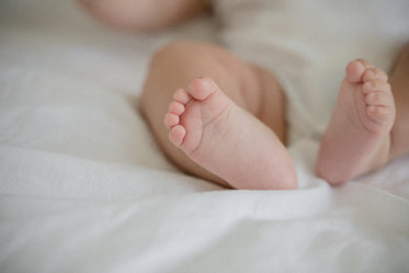 small feet of a baby on a white sheet