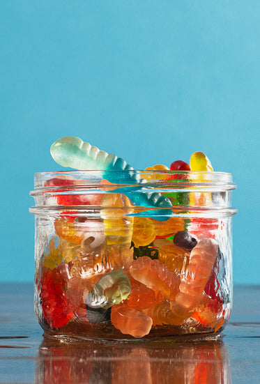 small glass jar filled to the top with gummy worms