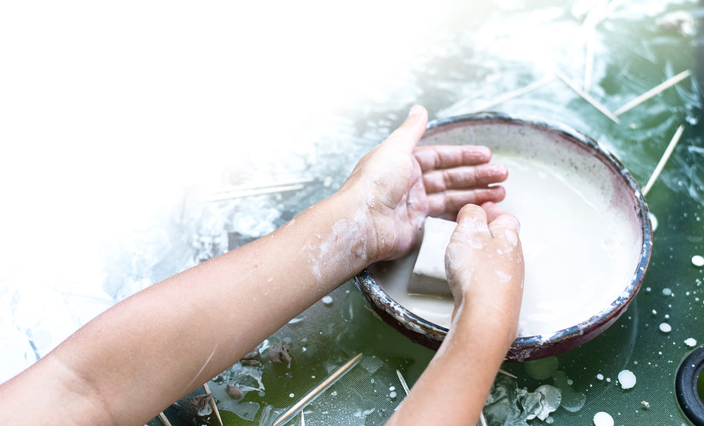 small hands get ready to sculpt with block of clay