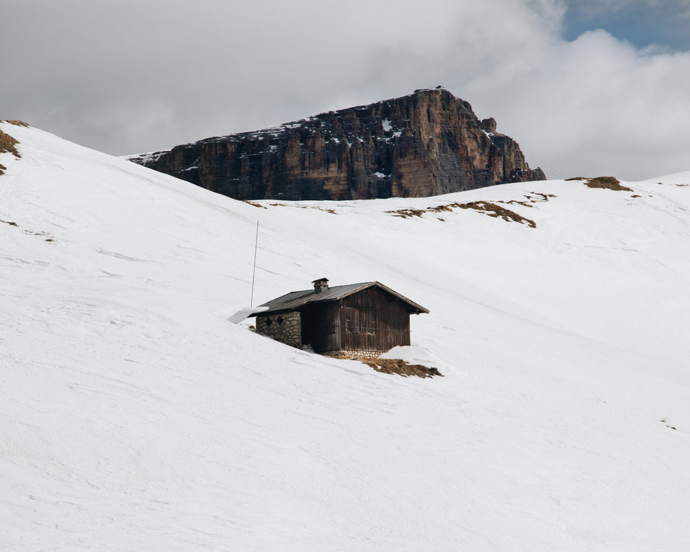 small log cabin surrounded by mountains