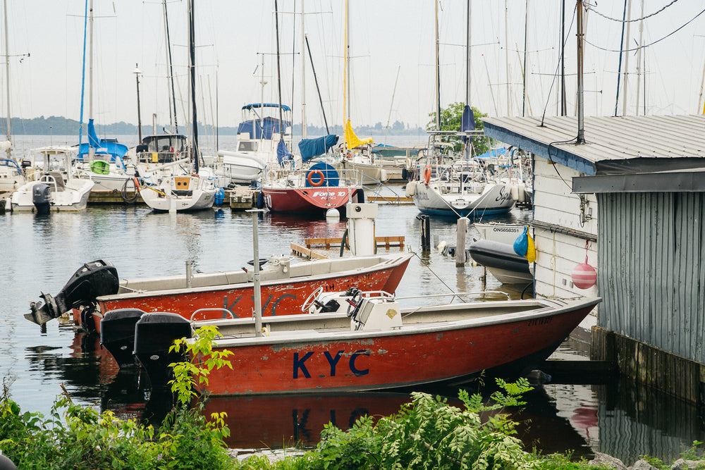 small pair of boats docked by boathouse