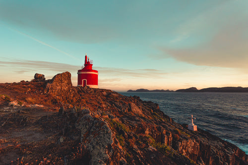 small red lighthouse in the rocks