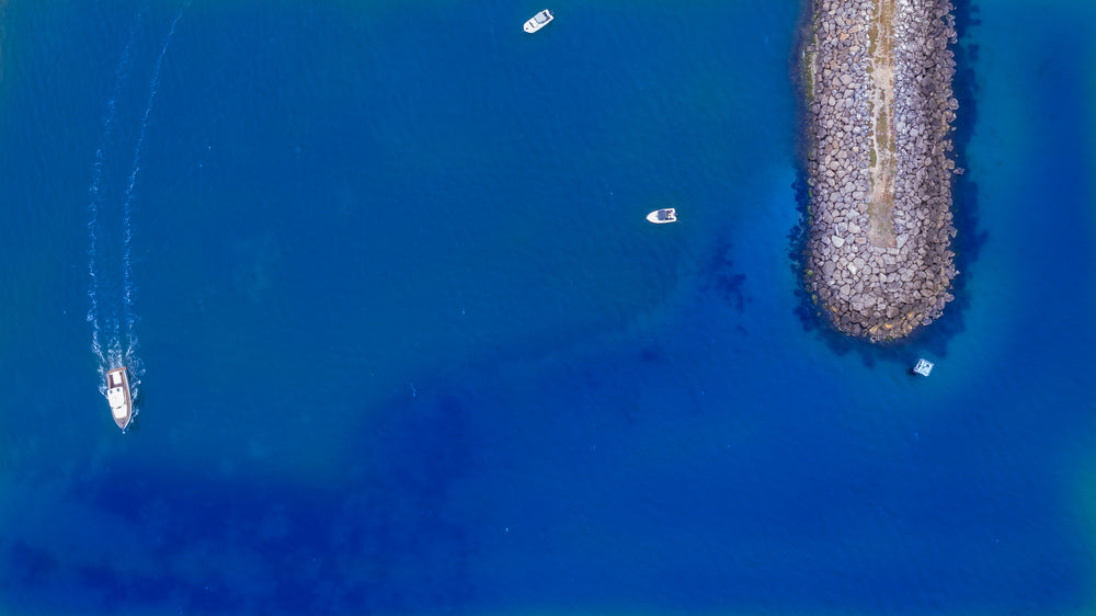 small rocky pier on calm blue sea