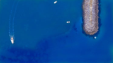 small rocky pier on calm blue sea