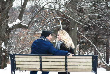 smiling couple laughing on park bench