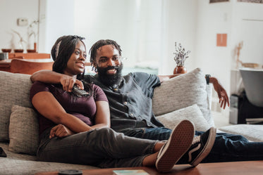 smiling couple on couch watching tv