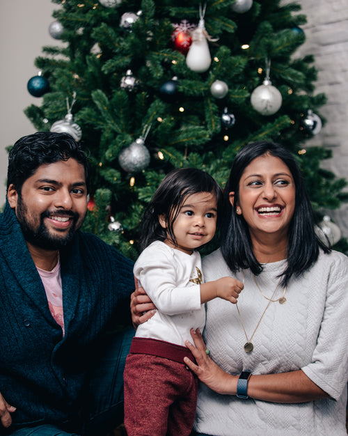 smiling family sitting around the christmas tree