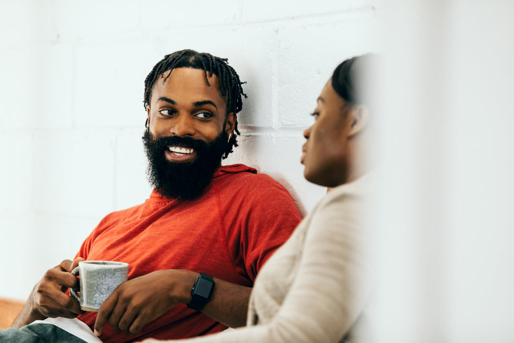 smiling man holds cup of tea