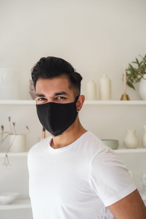 smiling man in black cloth face mask