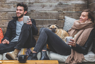 mulher e homem sorrindo com seu cachorro