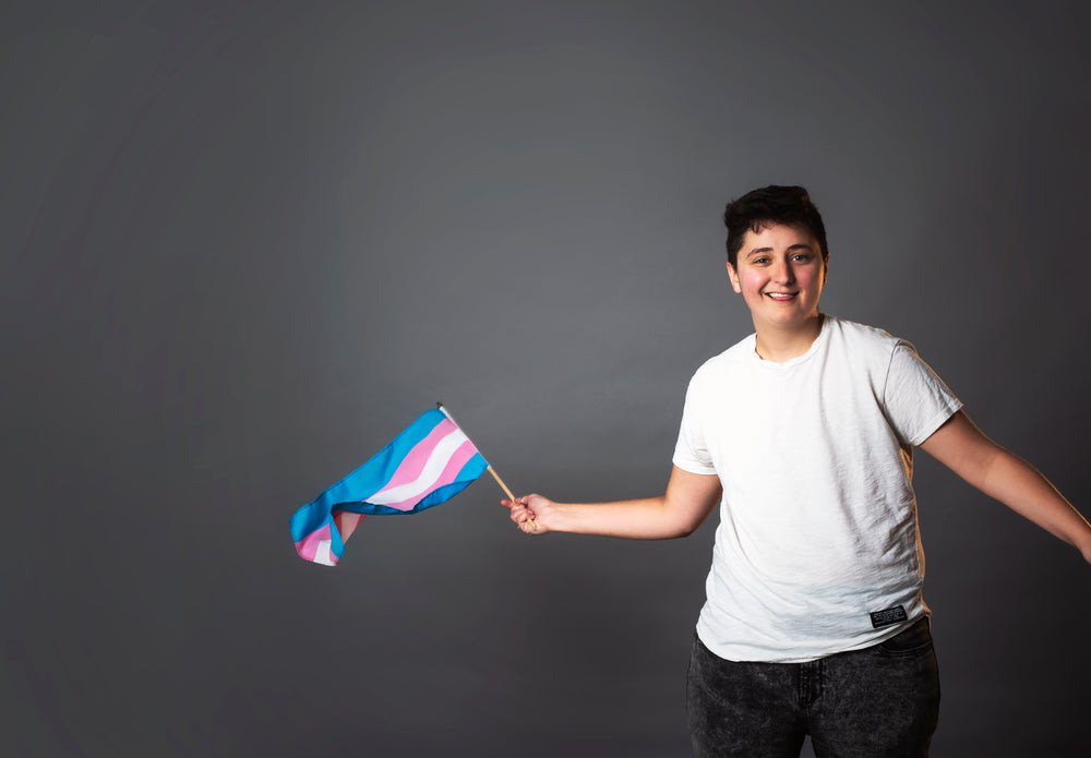 smiling person waving trans pride flag