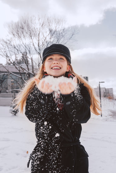 smiling woman in cap holding snow