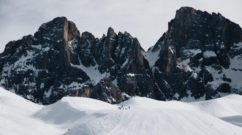 snow covered mountains with hikers