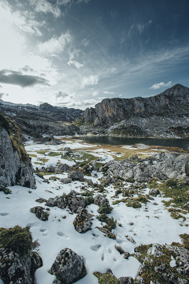 snow covered trail below the mountains