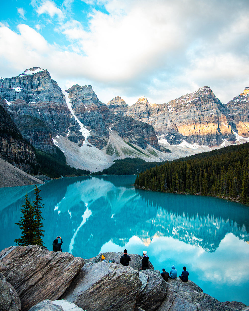 snowy mountains reflect in a blue pond