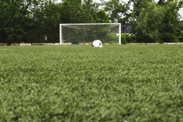 bola de futebol no campo com o gol atrás