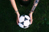 soccer ball in hands on grass